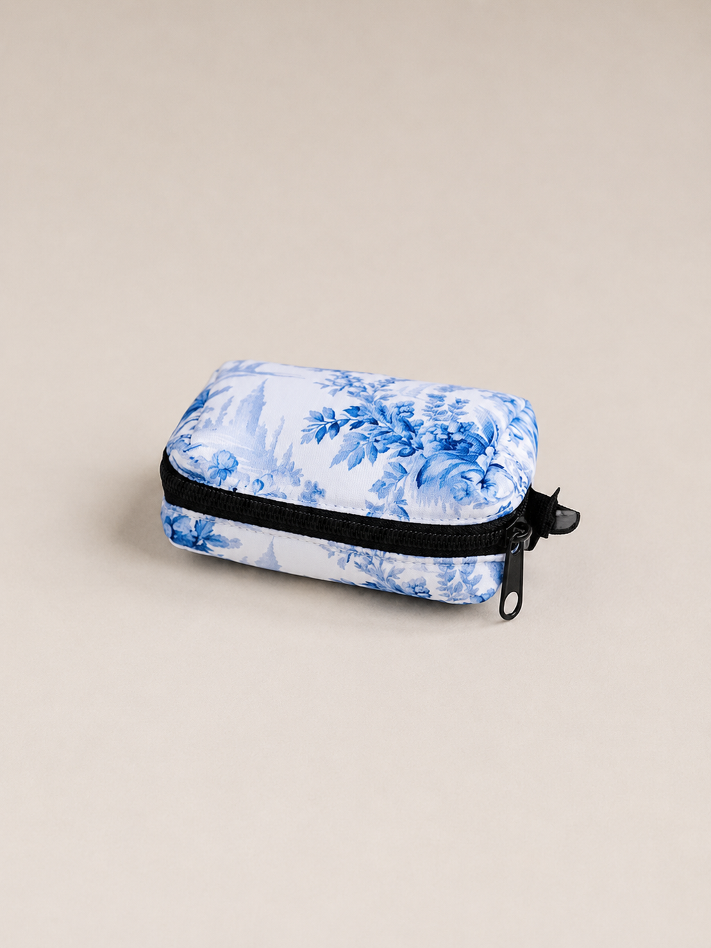 Enchanted floral-patterned poop bag holder with a black zipper on a beige background