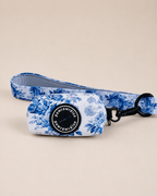 Enchanted floral dog poop bag holder and leash set with “Pawrawrdise” logo on a beige background