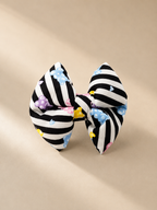 Black and white striped bow and jelly bears with colourful accents on a beige background