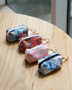 Set of four floral-patterned dog poop bag holder on a wooden surface